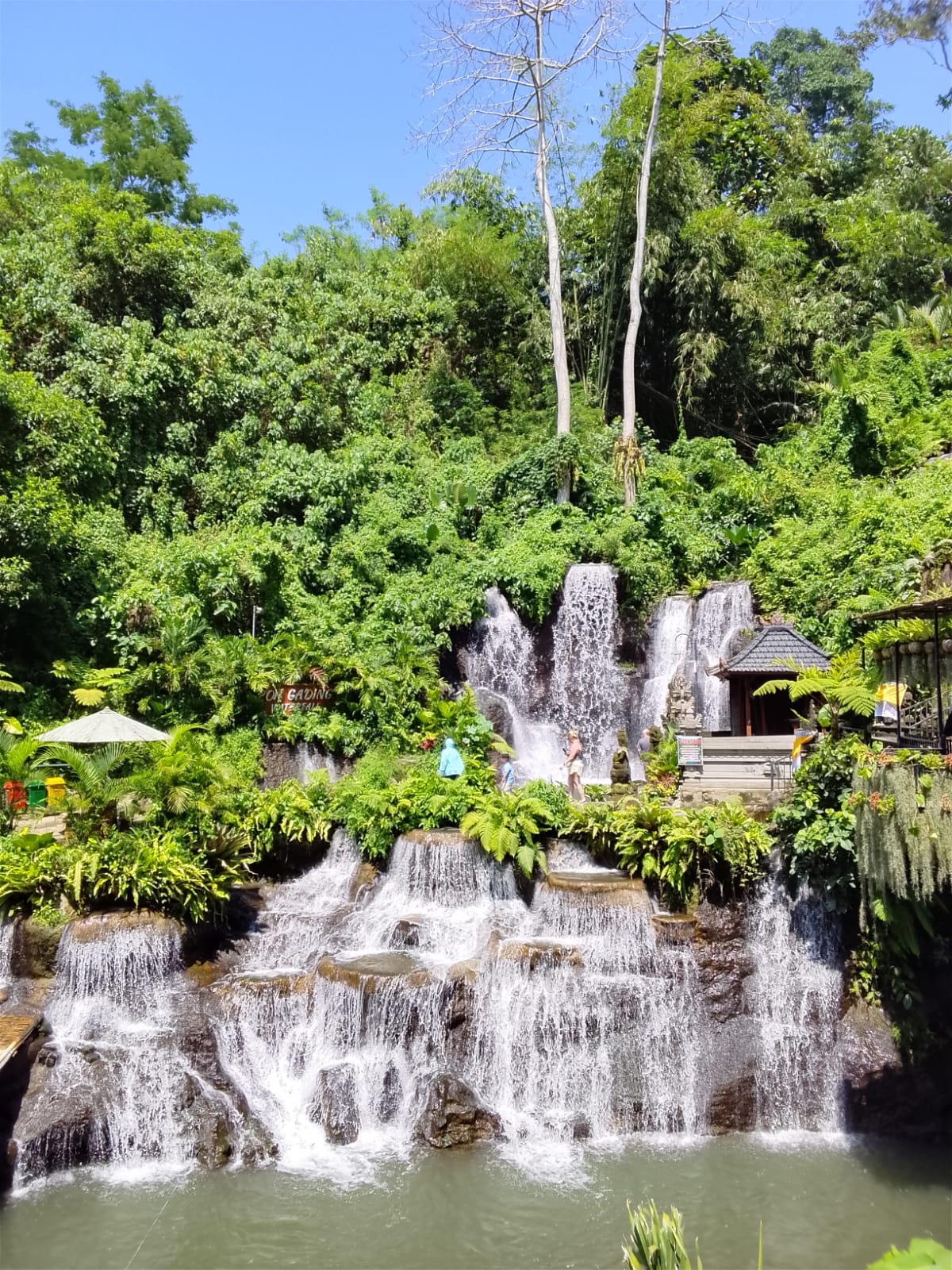 Multi-tiered Poh Gading Waterfall surrounded by greenery